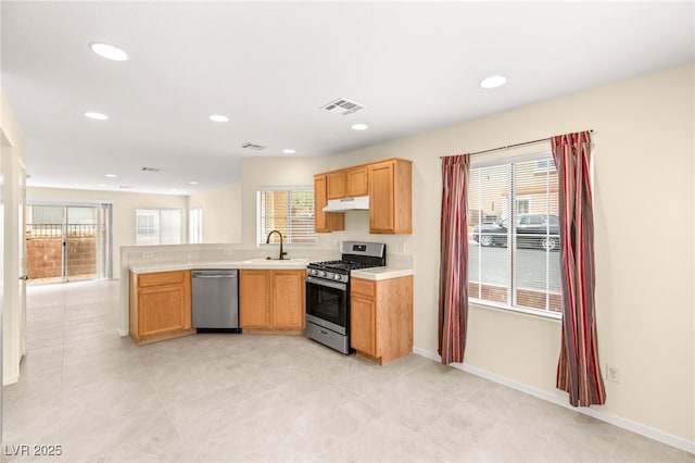 10437 Coyote Cub Ave, Las Vegas, NV 89129 - kitchen with stainless steel appliances, under cabinet range hood, light countertops, healthy amount of natural light, and recessed lighting