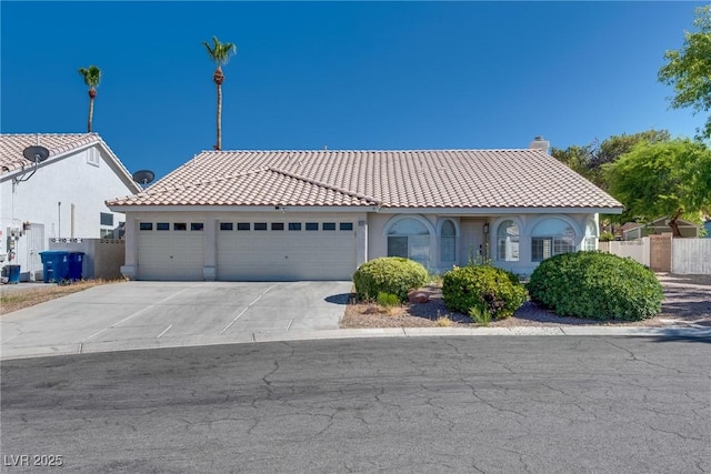 825 Royal Moon Ave, Las Vegas, NV 89123 - mediterranean / spanish house with a tiled roof, an attached garage, stucco siding, and concrete driveway