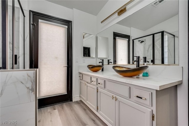 825 Royal Moon Ave, Las Vegas, NV 89123 - bathroom with a marble finish shower, double vanity, and wood finished floors