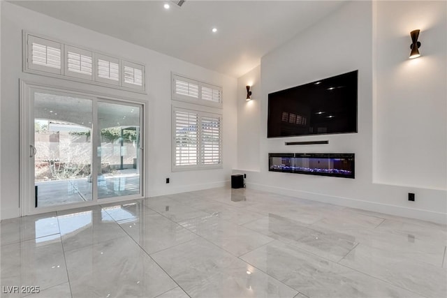 825 Royal Moon Ave, Las Vegas, NV 89123 - unfurnished living room with high vaulted ceiling, marble finish floors, a glass covered fireplace, and recessed lighting