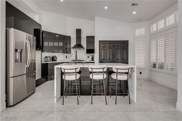 825 Royal Moon Ave, Las Vegas, NV 89123 - kitchen featuring stainless steel fridge, wall chimney range hood, modern cabinets, light countertops, and light marble finish flooring