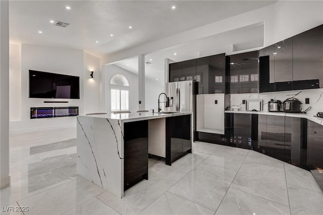 825 Royal Moon Ave, Las Vegas, NV 89123 - kitchen with modern cabinets, an island with sink, light countertops, light marble finish floors, and open floor plan