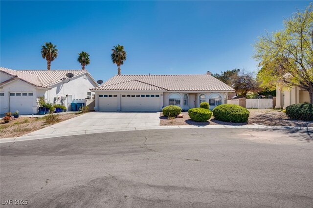 825 Royal Moon Ave, Las Vegas, NV 89123 - mediterranean / spanish house with a tiled roof, an attached garage, driveway, and stucco siding