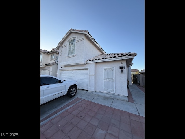 8064 Kentshire Dr, Las Vegas, NV 89117 - view of front of home with a tile roof, a garage, and stucco siding