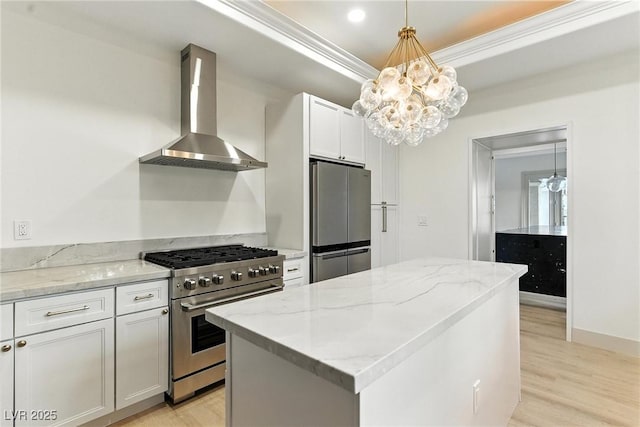 9408 Players Canyon Ct, Las Vegas, NV 89144 - kitchen with stainless steel appliances, wall chimney exhaust hood, light wood-type flooring, a kitchen island, and crown molding
