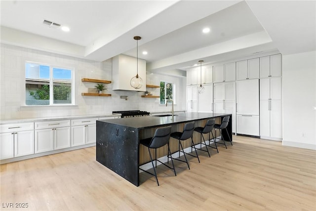 9408 Players Canyon Ct, Las Vegas, NV 89144 - kitchen with a tray ceiling, open shelves, light wood-type flooring, white cabinets, and recessed lighting