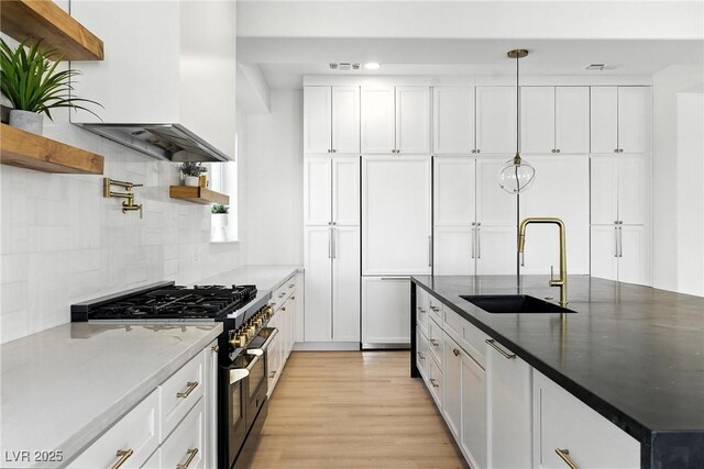 9408 Players Canyon Ct, Las Vegas, NV 89144 - kitchen with stainless steel stove, open shelves, extractor fan, white cabinets, and light wood-style floors