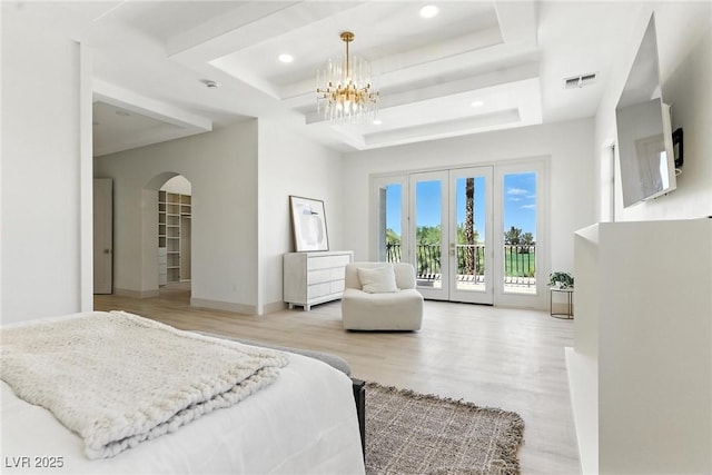 9408 Players Canyon Ct, Las Vegas, NV 89144 - bedroom with access to exterior, arched walkways, a tray ceiling, a chandelier, and wood finished floors
