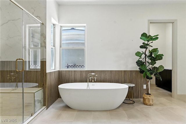 9408 Players Canyon Ct, Las Vegas, NV 89144 - bathroom with wainscoting, a freestanding tub, healthy amount of natural light, and a stall shower