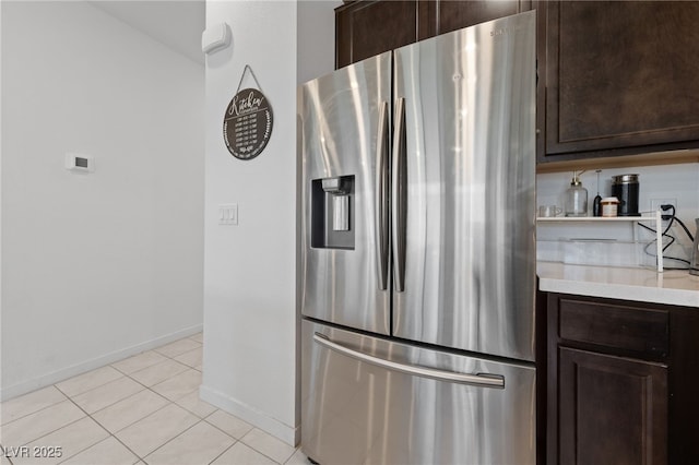 2732 Roman Palm Rd, North Las Vegas, NV 89086 - kitchen with stainless steel fridge, dark brown cabinetry, light countertops, and light tile patterned floors