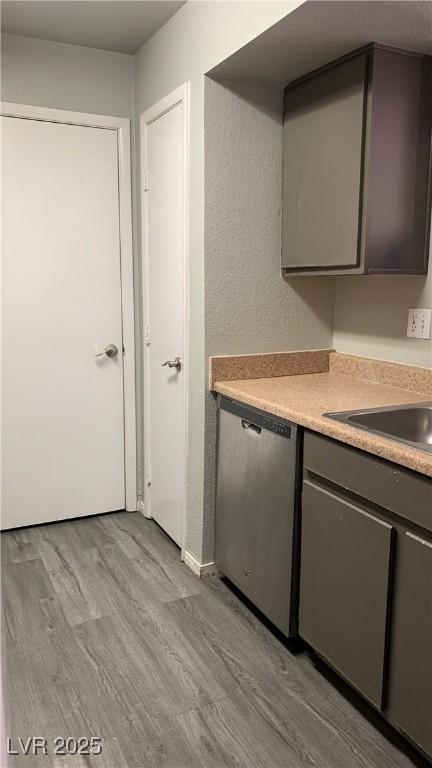 8101 W Flamingo Rd Unit 2110, Las Vegas, NV 89147 - kitchen featuring dishwasher, gray cabinets, light wood-type flooring, and light countertops