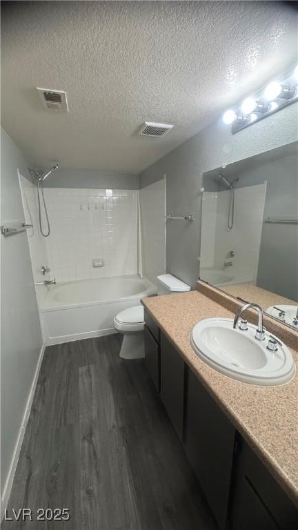 8101 W Flamingo Rd Unit 2110, Las Vegas, NV 89147 - bathroom with wood finished floors, a textured ceiling, vanity, and washtub / shower combination