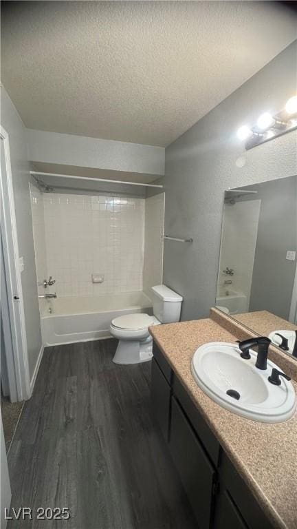 8101 W Flamingo Rd Unit 2110, Las Vegas, NV 89147 - bathroom featuring a textured ceiling, wood finished floors, vanity, and bathing tub / shower combination