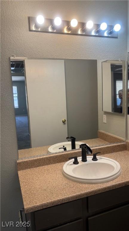 8101 W Flamingo Rd Unit 2110, Las Vegas, NV 89147 - bathroom with vanity and a textured wall