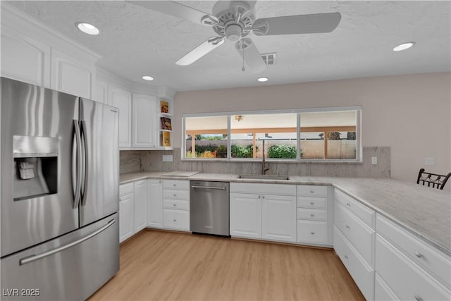 3753 Meadowcrest Dr, Las Vegas, NV 89121 - kitchen featuring appliances with stainless steel finishes, light wood finished floors, decorative backsplash, recessed lighting, and a textured ceiling