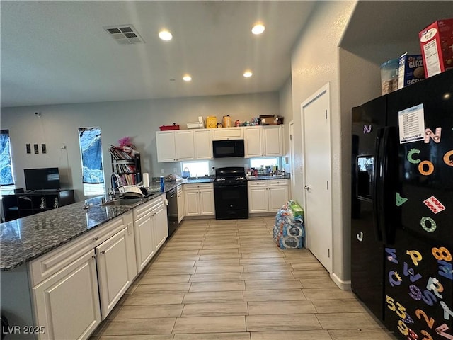 6450 Cinnamon Hazlenut St, North Las Vegas, NV 89084 - kitchen featuring black appliances, white cabinets, a peninsula, dark stone countertops, and recessed lighting