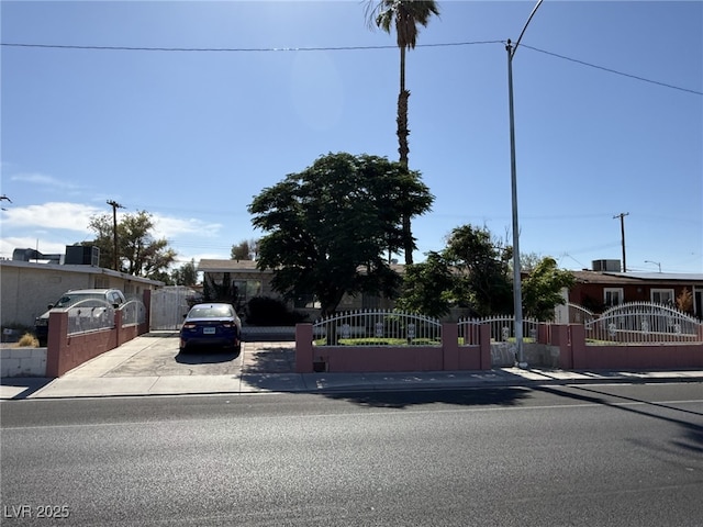 4567 S Nellis Blvd, Las Vegas, NV 89121 - view of property hidden behind natural elements featuring a gate, a fenced front yard, and driveway