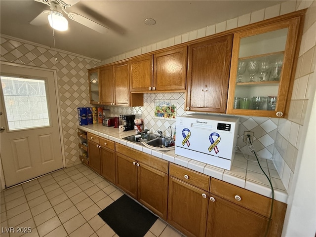 4567 S Nellis Blvd, Las Vegas, NV 89121 - kitchen with brown cabinets, light tile patterned floors, tile countertops, and tasteful backsplash