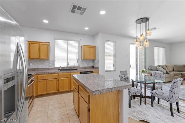 820 Peach Ave, North Las Vegas, NV 89032 - kitchen featuring stainless steel appliances, a center island, backsplash, open floor plan, and light tile patterned floors