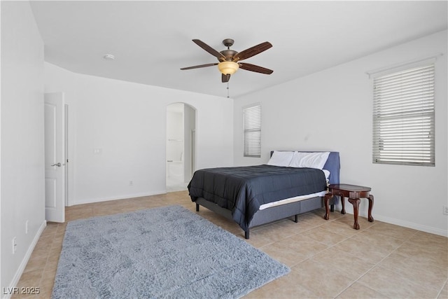 820 Peach Ave, North Las Vegas, NV 89032 - bedroom with arched walkways, light tile patterned floors, multiple windows, and a ceiling fan