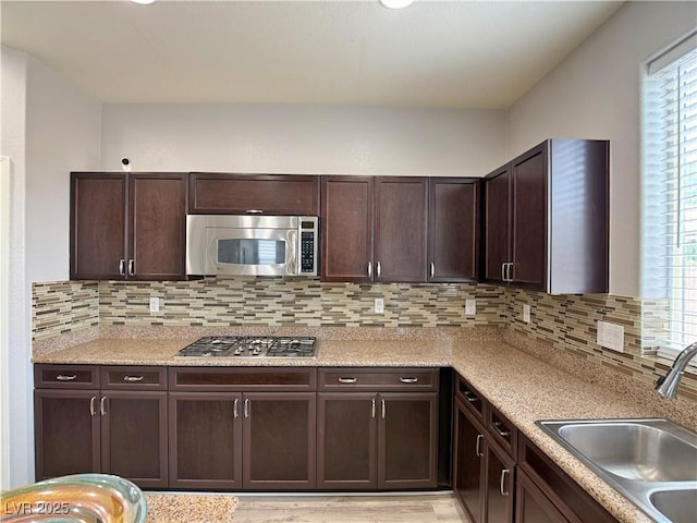 9604 Vital Crest St, Las Vegas, NV 89123 - kitchen featuring appliances with stainless steel finishes, dark brown cabinetry, plenty of natural light, and tasteful backsplash
