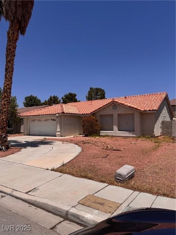 3644 Valley Dr, North Las Vegas, NV 89032 - view of front of home featuring a tile roof, stucco siding, a garage, and driveway