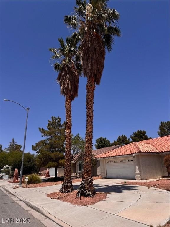 3644 Valley Dr, North Las Vegas, NV 89032 - view of front of home featuring driveway, an attached garage, a tile roof, and stucco siding
