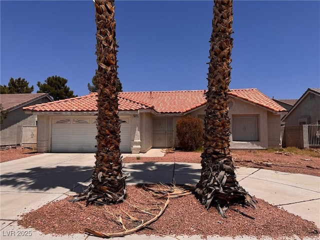 3644 Valley Dr, North Las Vegas, NV 89032 - mediterranean / spanish home featuring a tiled roof, stucco siding, a garage, and driveway