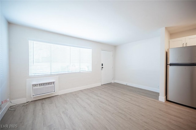 4600 University Center Dr Unit 72, Las Vegas, NV 89119 - unfurnished living room featuring light wood-style floors and an AC wall unit
