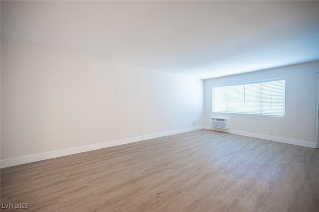 4600 University Center Dr Unit 72, Las Vegas, NV 89119 - empty room with light wood-type flooring and a wall mounted air conditioner