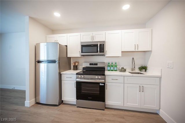 4600 University Center Dr Unit 72, Las Vegas, NV 89119 - kitchen featuring appliances with stainless steel finishes, white cabinets, light countertops, light wood-type flooring, and recessed lighting