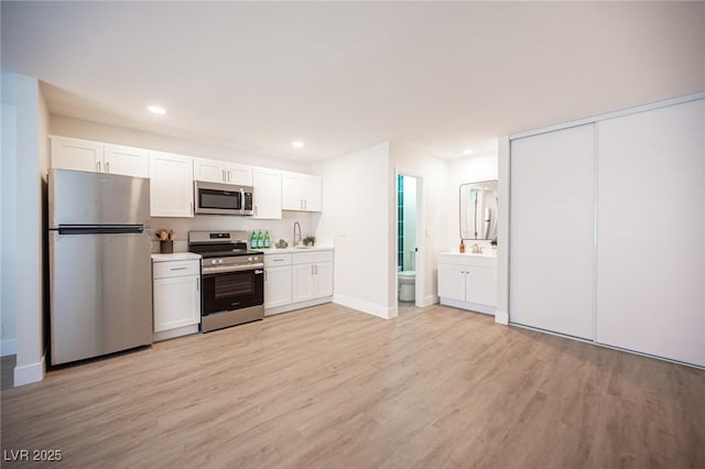 4600 University Center Dr Unit 72, Las Vegas, NV 89119 - kitchen featuring appliances with stainless steel finishes, light wood-style flooring, white cabinets, recessed lighting, and light countertops