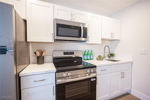 4600 University Center Dr Unit 72, Las Vegas, NV 89119 - kitchen featuring stainless steel appliances, white cabinetry, and light stone countertops