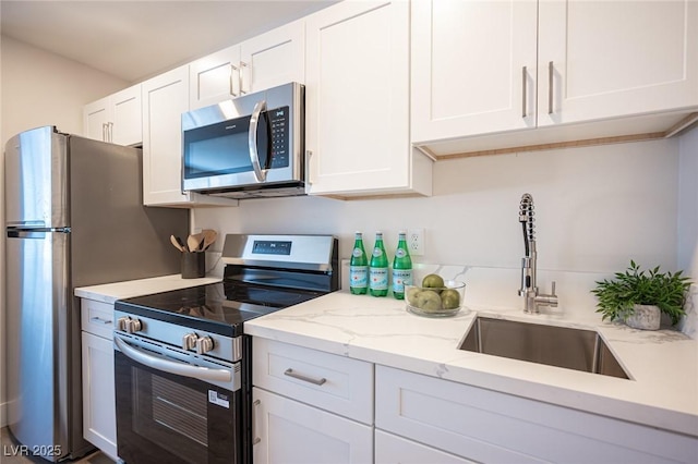 4600 University Center Dr Unit 72, Las Vegas, NV 89119 - kitchen with stainless steel appliances, white cabinetry, and light stone counters