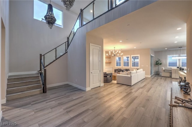 8984 Rolling Pietra St, Las Vegas, NV 89166 - living area with a chandelier, stairs, recessed lighting, light wood finished floors, and plenty of natural light