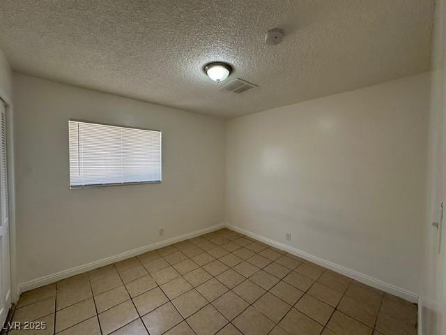 4200 Via Vaquero Ave, Las Vegas, NV 89102 - spare room featuring light tile patterned floors, a textured ceiling, and a smoke detector