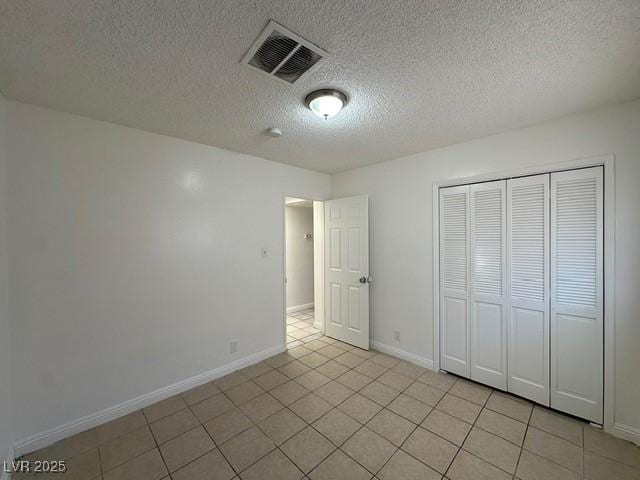4200 Via Vaquero Ave, Las Vegas, NV 89102 - unfurnished bedroom with light tile patterned floors, a textured ceiling, and a closet