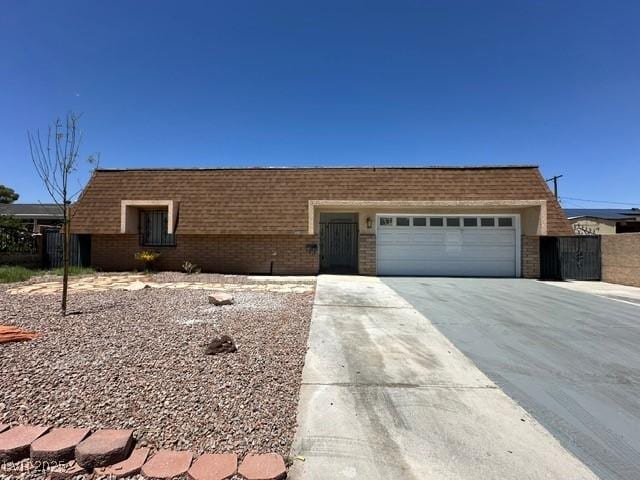 4200 Via Vaquero Ave, Las Vegas, NV 89102 - view of front of property with driveway, a garage, and brick siding
