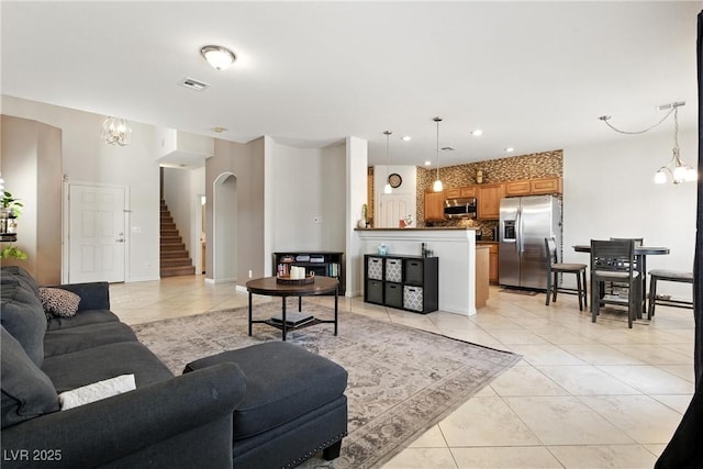 9004 Harbor Wind Ave, Las Vegas, NV 89178 - living area featuring light tile patterned flooring, a chandelier, arched walkways, stairway, and recessed lighting