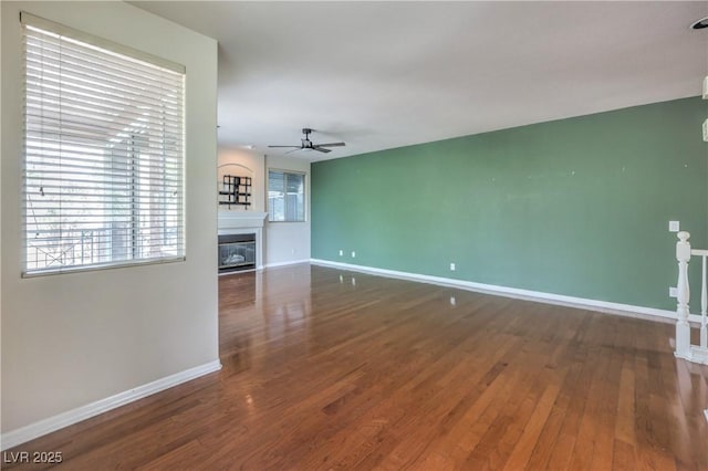 801 Dana Hills Ct Unit 101, Las Vegas, NV 89134 - unfurnished living room with ceiling fan, wood finished floors, and a glass covered fireplace