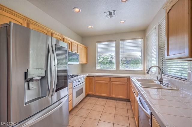 801 Dana Hills Ct Unit 101, Las Vegas, NV 89134 - kitchen with appliances with stainless steel finishes, tile counters, healthy amount of natural light, recessed lighting, and light tile patterned floors