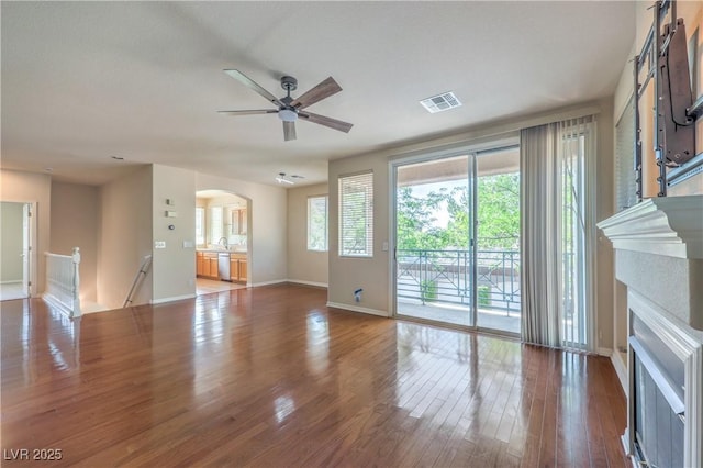801 Dana Hills Ct Unit 101, Las Vegas, NV 89134 - unfurnished living room with arched walkways, ceiling fan, wood finished floors, and a fireplace