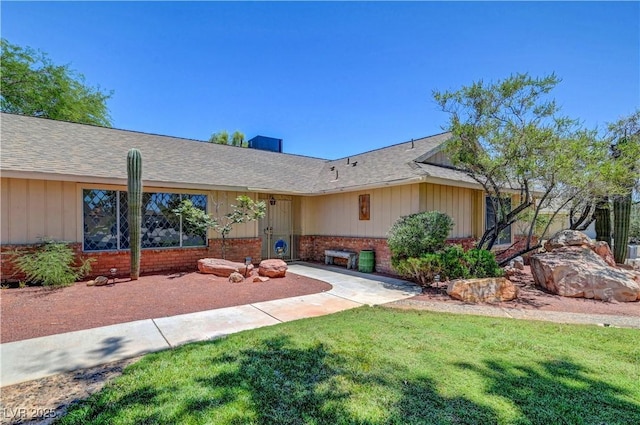 1705 Westwind Rd, Las Vegas, NV 89146 - ranch-style house with brick siding, a front yard, board and batten siding, and roof with shingles