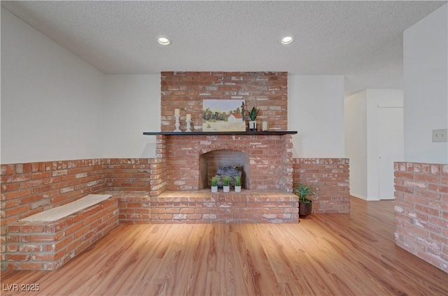 1705 Westwind Rd, Las Vegas, NV 89146 - unfurnished living room with a textured ceiling, wood finished floors, a fireplace, and recessed lighting