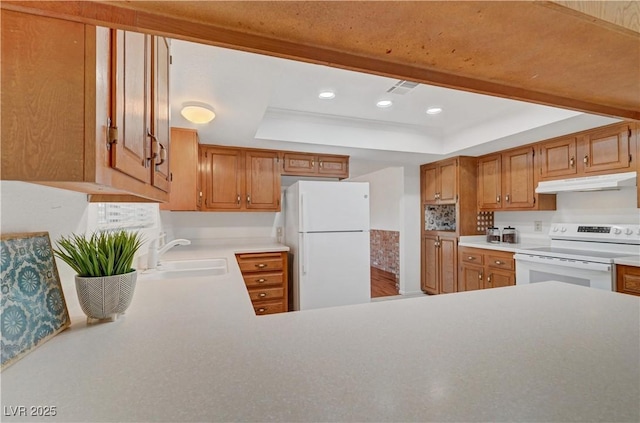 1705 Westwind Rd, Las Vegas, NV 89146 - kitchen featuring white appliances, under cabinet range hood, a raised ceiling, light countertops, and recessed lighting