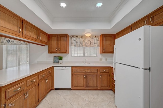 1705 Westwind Rd, Las Vegas, NV 89146 - kitchen featuring white appliances, a tray ceiling, brown cabinetry, light countertops, and a peninsula