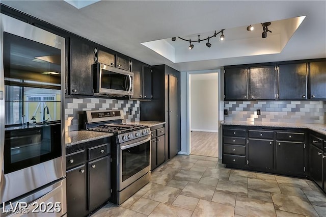 722 Barrie Ct, Henderson, NV 89002 - kitchen featuring appliances with stainless steel finishes, a raised ceiling, tasteful backsplash, and dark cabinetry