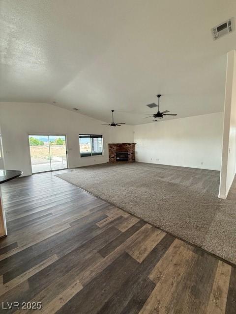 1830 Justine Ct, Pahrump, NV 89048 - unfurnished living room with lofted ceiling, ceiling fan, a fireplace, and wood finished floors