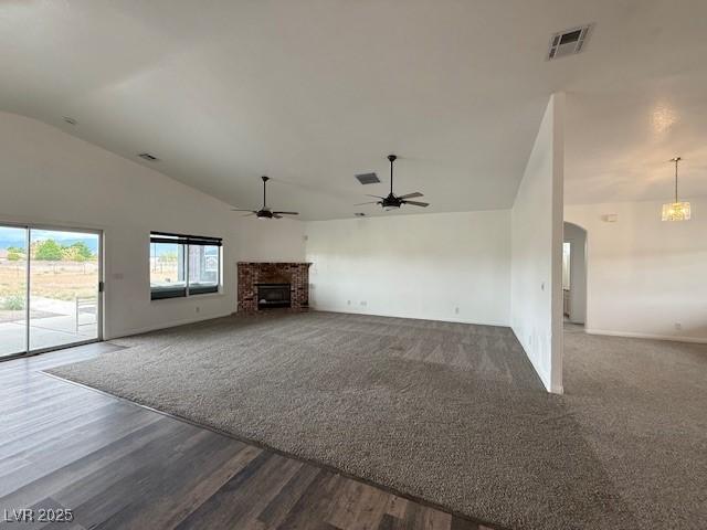 1830 Justine Ct, Pahrump, NV 89048 - unfurnished living room featuring ceiling fan, a fireplace, a chandelier, dark wood-style flooring, and high vaulted ceiling