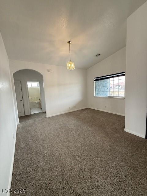 1830 Justine Ct, Pahrump, NV 89048 - unfurnished room with arched walkways, dark colored carpet, a chandelier, and vaulted ceiling